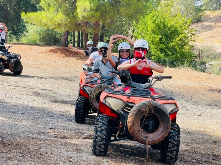 Zwei Personen auf einem roten Quad auf einem Waldweg